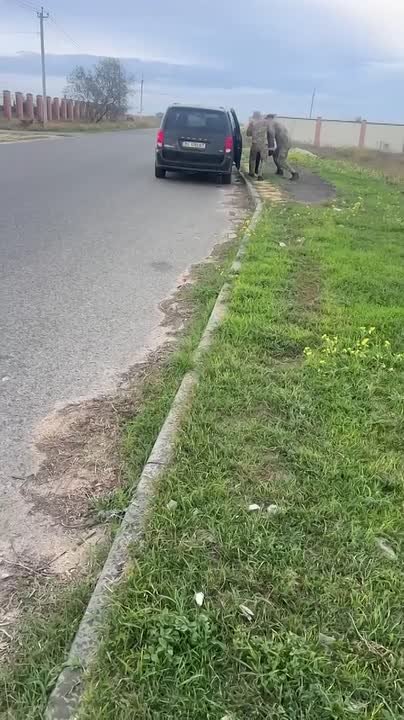 Местная жительница просит сотрудника ТЦК освободить её знакомого, которого они задержали на её глазах